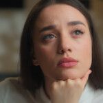 portrait frau mit braunen haaren schaut fragend