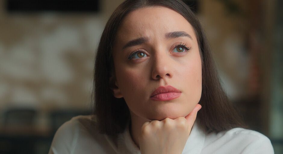 portrait frau mit braunen haaren schaut fragend